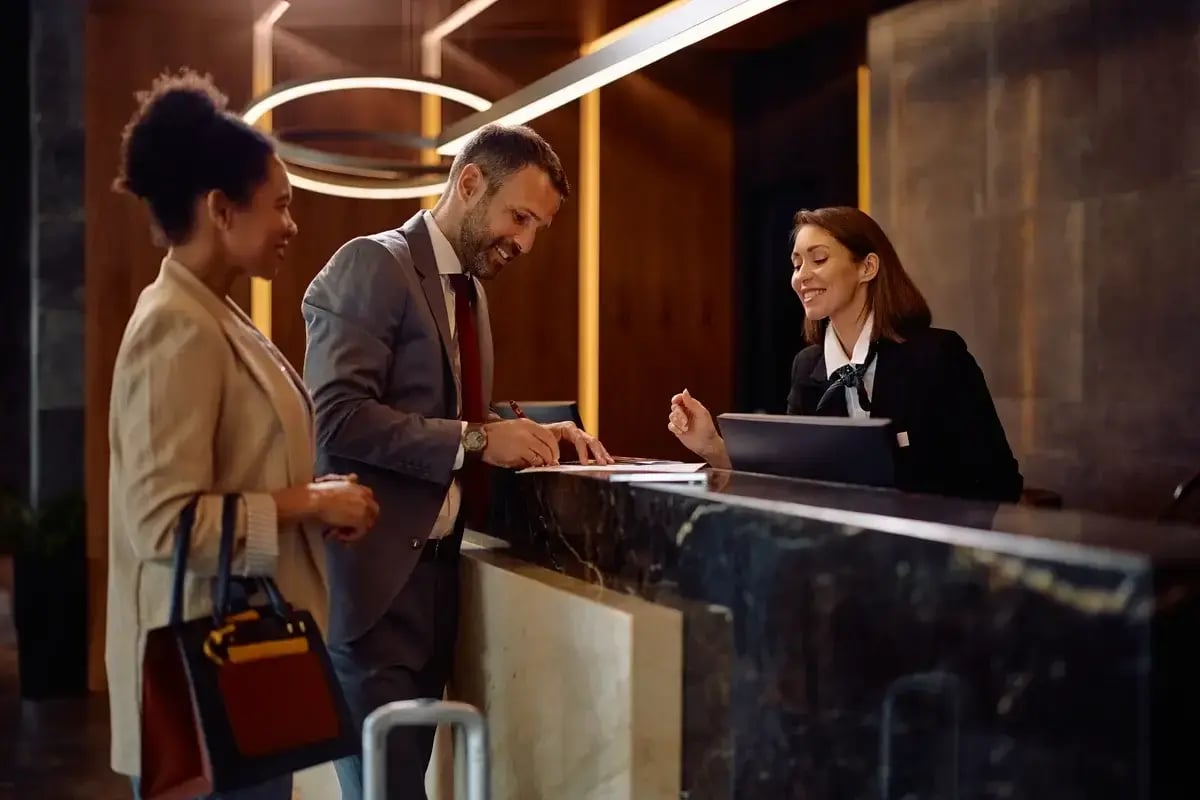 Hotel staff assisting guests at the front desk