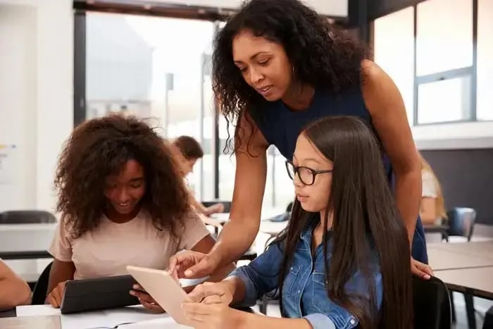 Teacher helping students with a tablet