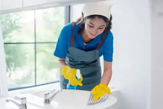 Worker cleaning a sink