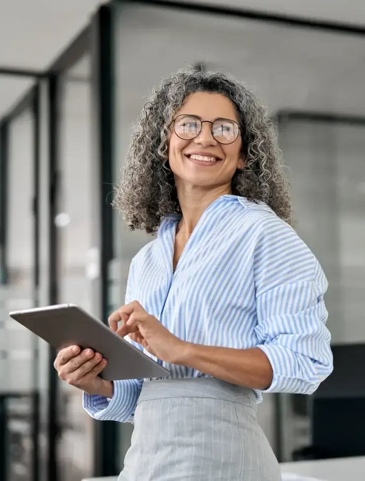 Smiling woman holding a tablet in an office